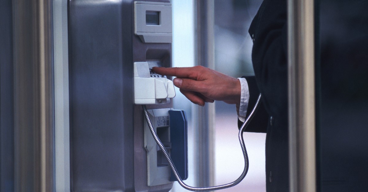 Une personne dans une cabine téléphonique passant un appel